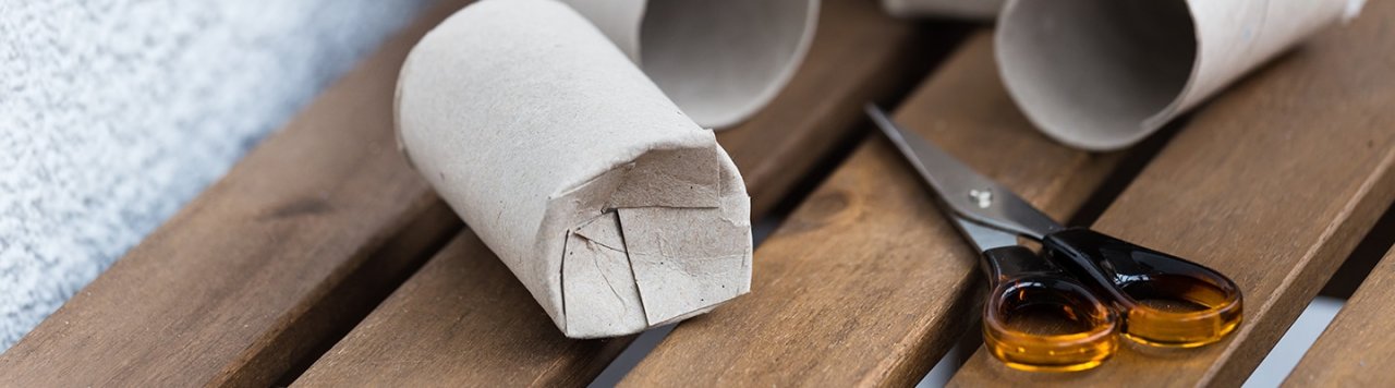 Toilet rolls sitting on a bench with scissors, ready to be used for craft activities.