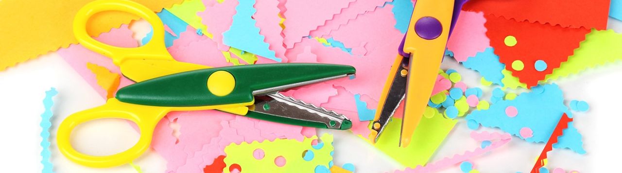 Colourful crafting scissors sitting on bright paper.